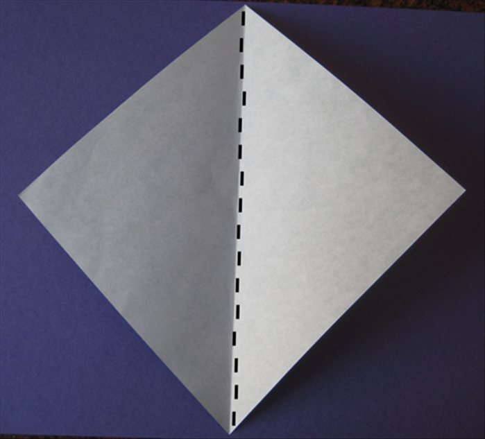 If your paper is colored on one side place the colored side facing down.

Fold the paper in half. 
Unfold
