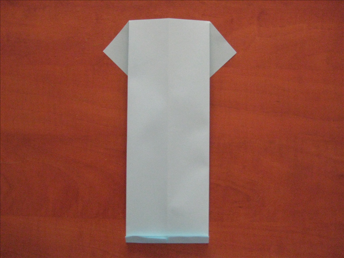 Flip the paper over to the back side.
Make a small fold at the bottom. This fold will be the collar.
