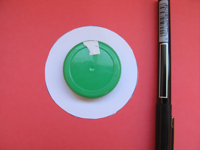 Place the cap in the center of the black circle.
Trace the circle and cut it out.
*You can stab a hole in the center for an entrance point for you scissors.
